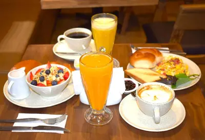 a table with breakfast foods and two glasses of orange juice at CASA MONTES PARDO in Cusco