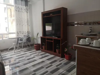 a living room with a flat screen tv and a table at Mi Chanchamayo, family. in La Merced