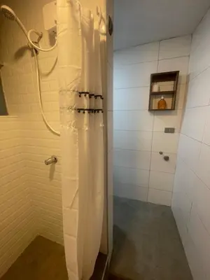 a shower with a white shower curtain in a bathroom at Huancayo Suite 3, cómodo MiniDpto cama matrimonial in Huancayo