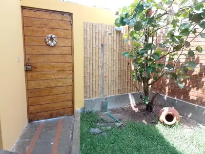a wooden door next to a tree next to a fence at Arica Surf & Beach House in Arica