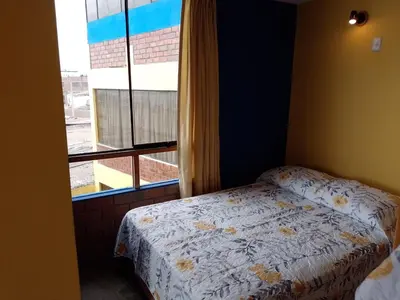 a bedroom with a bed and a window at Arica Surf & Beach House in Arica