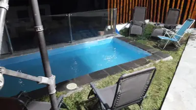a swimming pool with chairs in a backyard at Casa en cineguilla in Cieneguilla