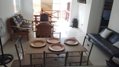 a table with plates on it in a living room at Casa en cineguilla in Cieneguilla