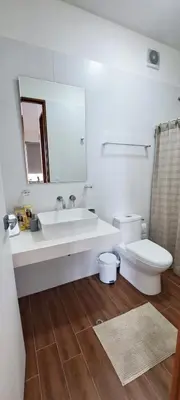 a bathroom with a sink and a toilet and a mirror at VK Loft - Apartamento en Miraflores in Lima