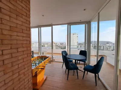 a dining room with a table and chairs and windows at VK Loft - Apartamento en Miraflores in Lima