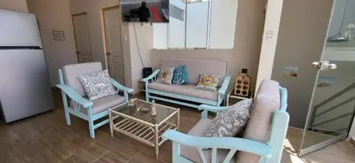a living room with two chairs and a table at L & P Apart Punta Hermosa in Punta Hermosa