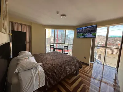 a bedroom with a bed and a flat screen tv at Hotel Inka Palace Huayna Ccapac Cusco in Cusco