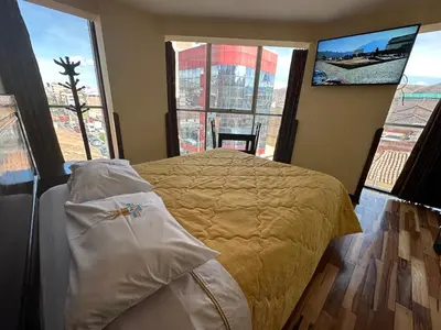 a bedroom with a bed with a view of a city at Hotel Inka Palace Huayna Ccapac Cusco in Cusco