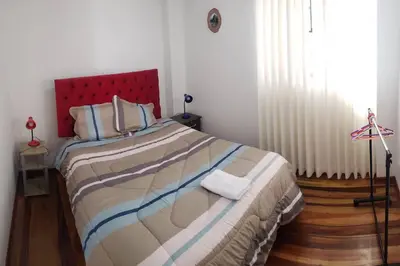 a bedroom with a large bed with a red headboard at Cusco Central Aparment in Cusco