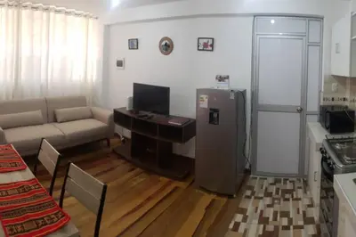 a living room with a couch and a refrigerator at Cusco Central Aparment in Cusco