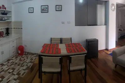 a kitchen with a table and chairs and a kitchen with a counter at Cusco Central Aparment in Cusco