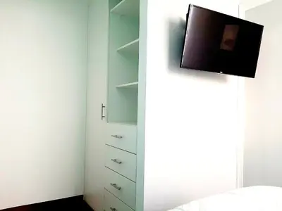 a bedroom with a tv on the wall next to a bed at Hermoso apartamento Unidos En Familia en JESÚS MARÍA in Lima