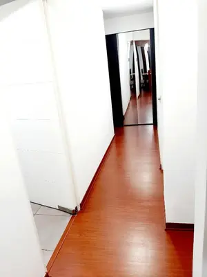 a hallway with white doors and a wooden floor at Hermoso apartamento Unidos En Familia en JESÚS MARÍA in Lima