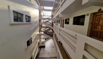 an empty hallway of a building with a spiral staircase at Paiva in Lima