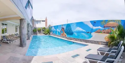 a swimming pool with chairs and a mural on a building at Hotel Savilayo in Ica