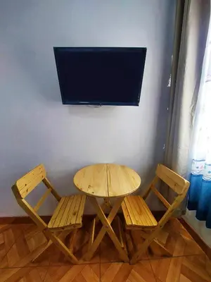 a table and two chairs with a television on a wall at Kasanty House in Paracas