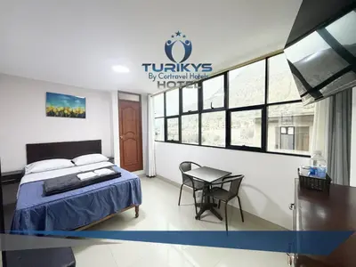 a hotel room with a bed and a table at Hotel Turikys Churin in Churín