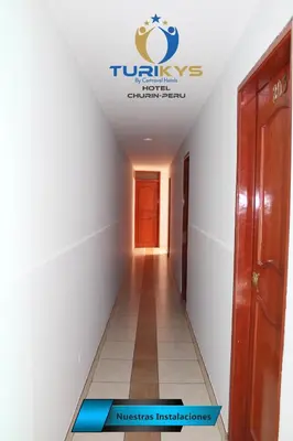 a hallway in a building with a sign on the ceiling at Hotel Turikys Churin in Churín