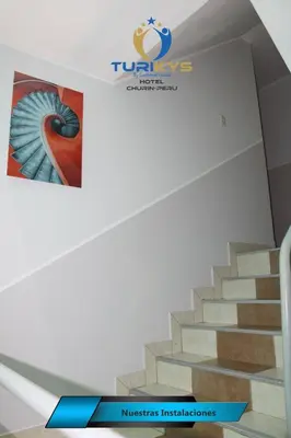 a picture of a staircase with a sign on the wall at Hotel Turikys Churin in Churín
