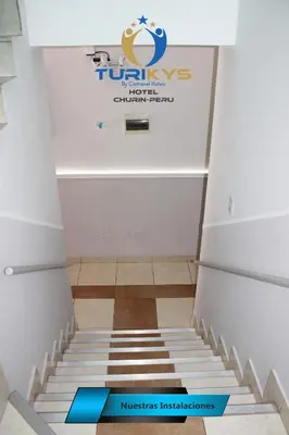 a staircase in a room with a sign on the wall at Hotel Turikys Churin in Churín
