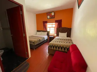 a room with two beds and a couch and a window at Mundo Viajero Saphy in Cusco