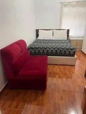 a red couch and a bed in a room at Mundo Viajero Saphy in Cusco