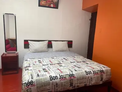 a bedroom with a bed with a comforter and a mirror at Mundo Viajero Saphy in Cusco