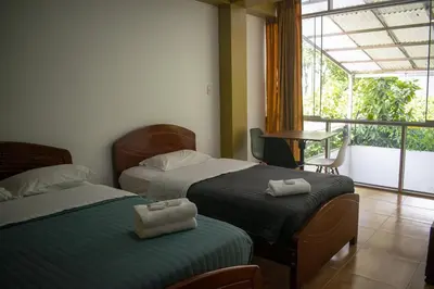 a hotel room with two beds and a balcony at GOLDEN DOOR in La Merced