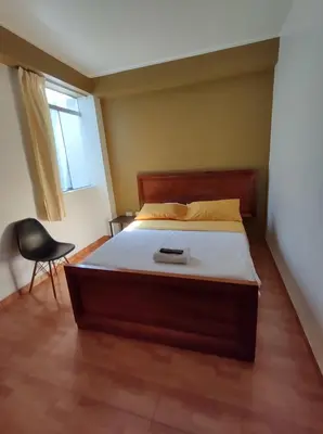 a bedroom with a bed and a chair and a window at GOLDEN DOOR in La Merced