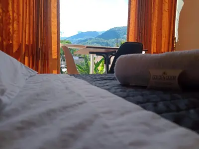 a bed in a room with a view of a table at GOLDEN DOOR in La Merced
