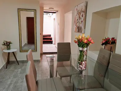 a living room with a vase of flowers on a glass table at Centro Cusco Inti in Cusco