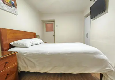a bedroom with a large white bed and a dresser at Centro Cusco Inti in Cusco