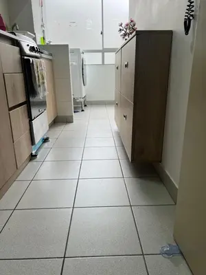 a kitchen with a tiled floor with a counter and cabinets at Lindo Apartamento en Condominio Privado in Lima