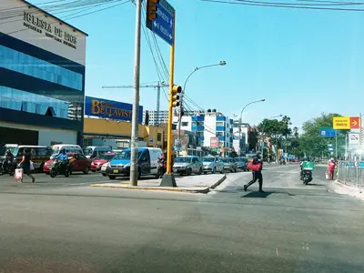 a man crossing a street in a busy city at Lindo Apartamento en Condominio Privado in Lima