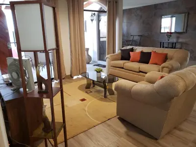 a living room with a couch and a table at Amplio y Acogedor Departamento en San Miguel, Lima in Lima