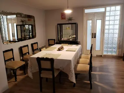a dining room with a white table and chairs at Amplio y Acogedor Departamento en San Miguel, Lima in Lima