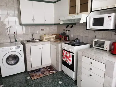 a kitchen with white cabinets and a washer and dryer at Amplio y Acogedor Departamento en San Miguel, Lima in Lima