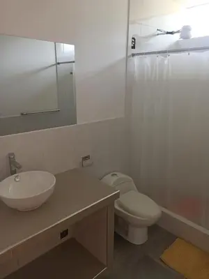 a bathroom with a sink and a toilet and a mirror at Hermosa y espléndida casa en Oxapampa in Oxapampa
