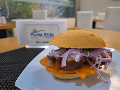 a sandwich on a white plate on a table at Hotel Punta Rocas - Huacho in Huacho