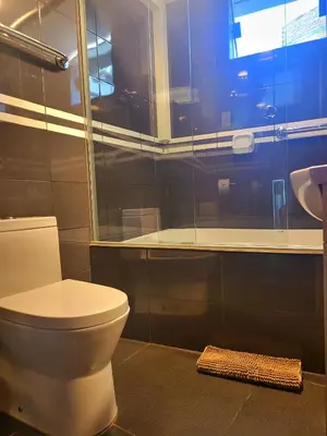 a bathroom with a toilet and a sink and a window at Hotel Punta Rocas - Huacho in Huacho