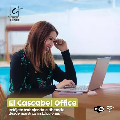 a woman sitting at a table with a laptop computer at Hospedaje El Cascabel in Sunampe
