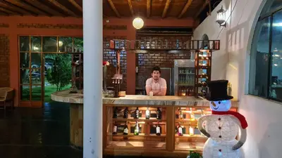 a man sitting at a counter in a bar at Hospedaje El Cascabel in Sunampe