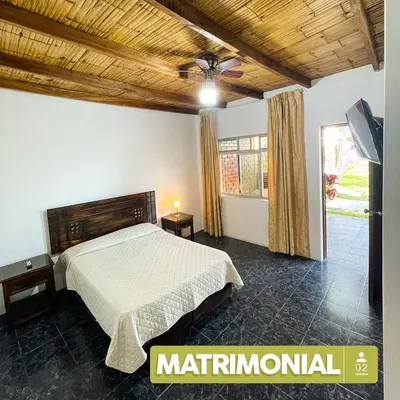a bedroom with a bed with a wooden ceiling at Hospedaje El Cascabel in Sunampe