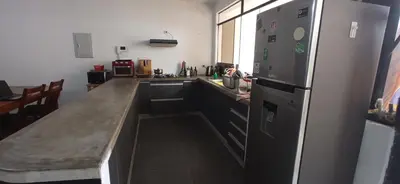 a kitchen with a large counter and a refrigerator at Bravo Hostels: Surf House in Punta Hermosa