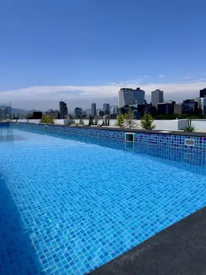 a blue swimming pool with a city in the background at 2BR 2BTH San Isidro Apartment in Lima