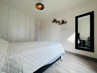 a bedroom with a white bed and a mirror at 2BR 2BTH San Isidro Apartment in Lima