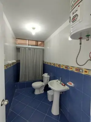 a blue tiled bathroom with a toilet and a sink at J&B Aparment 1 Punta Hermosa in Punta Hermosa