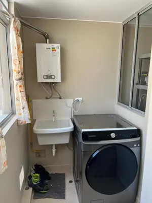 a small bathroom with a washing machine and a sink at Moderno Apartamento en Condominio Alto Venezuela in Lima