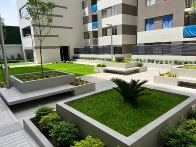 a courtyard of a building with plants and grass at Moderno Apartamento en Condominio Alto Venezuela in Lima