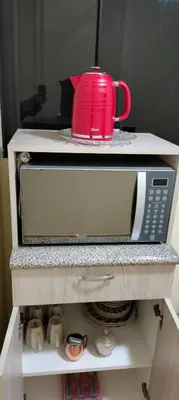 a microwave with a red mug on top of it at Casa Bonita in Lima
